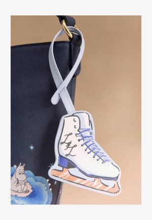 Laukkua, jossa on meripihkanvärinen materiaali, ja joka sisältää valkoisen jääkiekkovalkeen riipuksen sinisillä yksityiskohdilla ja nauhoilla, kiinnitettynä vaaleansinisellä hihnalla.