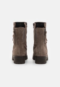 Brune nubuck ankelstøvler med en strukturert finish, glidelås lukking på begge sider, og en chunky, mønstrete såle. Har en solid hæl.