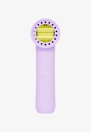 Purple skincare device with a circular head featuring yellow accents and multiple holes. Smooth texture, elongated body, and brand name "FOREO" printed.