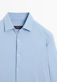 Jasnoniebieska koszula z kołnierzykiem o gładkiej fakturze, z zapięciem na guziki z przodu i metką z napisem "Massimo Dutti".