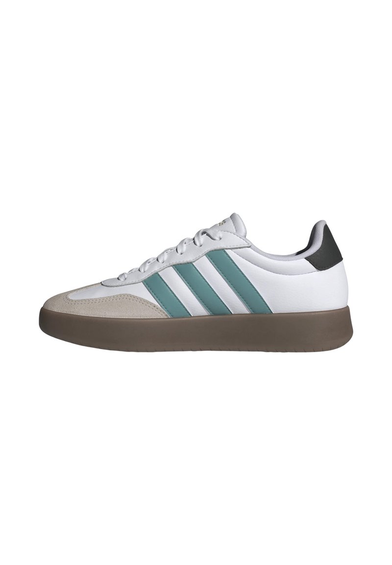 Zapatillas deportivas blancas con rayas turquesa, puntera de ante y suela de goma marrón. Textura suave, diseño de cordones y tacón mínimo.
