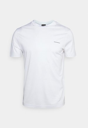 Camiseta branca de algodão com mangas curtas, gola redonda e um pequeno logótipo bordado no lado esquerdo do peito. Textura suave, corte casual.