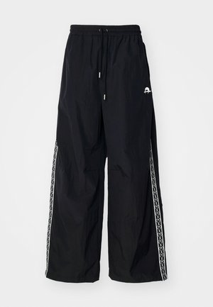 Schwarze, leichte Hose mit lockerer Passform. Sie verfügt über einen elastischen Bund, eine Kordel und weiße gemusterte Seitenstreifen.