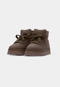 Brune suede høye sneakers med tykke snører, polstret krage og teksturert logodetalj på tungen og sidene. Gummisåle.