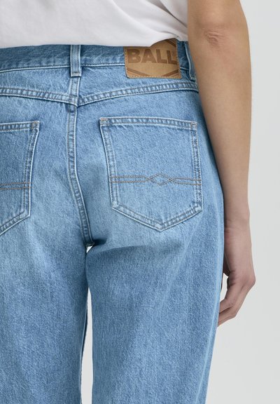 Jeans de mezclilla azul claro que cuentan con una etiqueta de cuero en la cinturilla etiquetada como "BALL" y dos bolsillos traseros con sutiles detalles de costura.