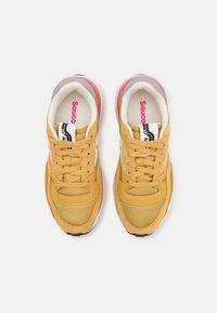 Yellow suede and mesh sneakers with pink and grey accents, featuring laces, a padded collar, and a textured rubber sole.