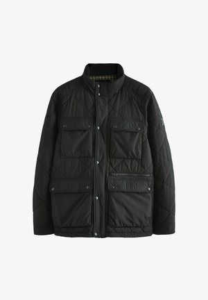 Veste matelassée noire avec un col haut, fermeture par pressions, deux poches poitrine et une poche zippée. L'intérieur présente un motif à carreaux.