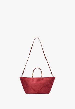 Punainen mokkatoimitasku, jossa on geometrinen muotoilu. Varustettu yläkahvalla ja irrotettavalla olkahihnalla, jossa on koristeellisia metalliosia.