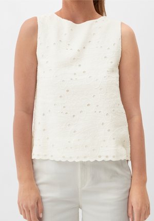 Top sans manches blanc en tissu texturé présentant des motifs de feuilles brodés et des découpes, ourlé de bords festonnés.