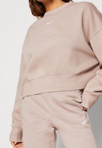Ljusrosa Nike sweatshirt med rund halsringning, ribbade ärmslut och nederkant. Har en liten vit logga på bröstet. Mjuk och skön material.
