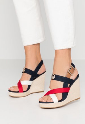 Sandalias cuña con suela de cuerda natural, tiras en azul marino, rojo y blanco; detalle de hebilla en la tira del tobillo, diseño de punta abierta.
