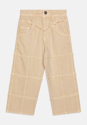 Pantalones cortos beige de algodón texturizado, con costuras deshilachadas, dos bolsillos laterales y un botón en la cintura.
