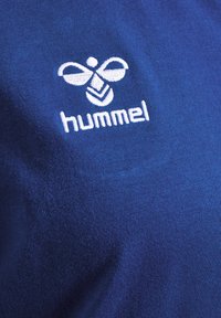 Blauwe katoenen t-shirt met een soepele textuur, voorzien van een wit geborduurd logo van een bij en het woord "hummel" eronder.