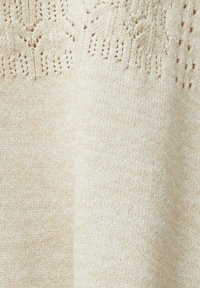 Jasnobeżowy sweter wykonany na drutach, z teksturowanym wzorem przy dekolcie, o miękkim, gładkim materiale i delikatnych niuansach kolorystycznych.