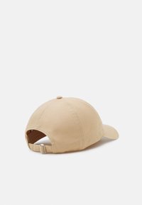 Beige Baseballcap aus Stoff, mit runder Krone, gebogenem Schirm und verstellbarem Riemen mit einer Metall-Schnalle auf der Rückseite.