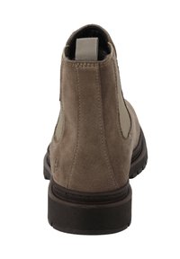 Brązowe zamszowe botki za kostkę z elastycznymi panelami bocznymi, zaokrąglonym noskiem i teksturowaną gumową podeszwą. Logo wytłoczone na pięcie.