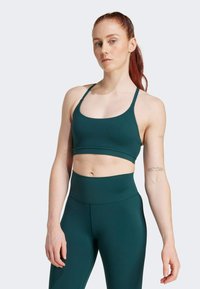 Sujetador deportivo en tono azul claro con tirantes delgados y una banda ancha, combinado con leggins de tiro alto en el mismo tono. Tejido suave con ligera elasticidad.