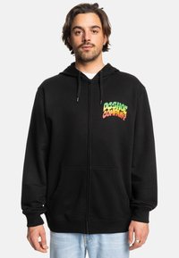 Black zip-up hoodie made of cotton. Features front pockets and a colorful "DC Shoe Company" logo on the chest. Relaxed fit.