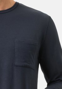 Granatowa koszula z długim rękawem wykonana z miękkiego materiału, z kieszenią na piersi o czystym, prostym designie oraz okrągłym dekoltem. Gładka faktura, bez wzorów.