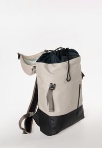 Zaino con una parte superiore grigio chiaro, una parte inferiore nera, spallacci regolabili, chiusura a coulisse e tasca laterale con zip. Finitura matte liscia.