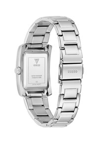 Montre en acier inoxydable argenté avec un cadran rectangulaire, bracelet en métal linké, caractéristiques de résistance à l'eau et marquage "GUESS" sur le bracelet.