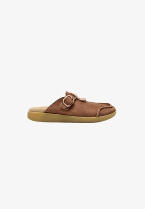 Zapato marrón tipo slip-on con puntera redondeada, correa lateral con hebilla y suela color tostado claro sobre fondo blanco.