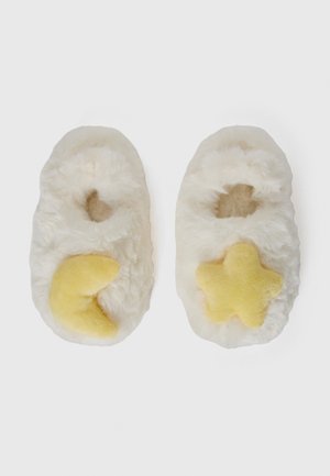 Chaussons en laine blancs avec un croissant de lune jaune à gauche et une étoile à droite, posés à plat sur un fond blanc.