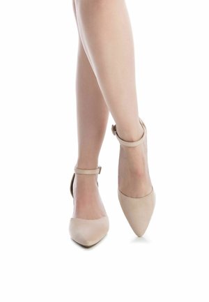 Tacones de ante beige con punta afilada y correa en el tobillo, con una textura suave y un perfil delgado.