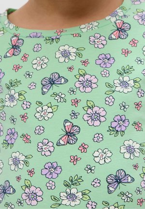 Groen stof met een bloem- en vlinderpatroon in roze, paars en wit. Heeft een ronde halslijn en een zachte, gladde textuur.