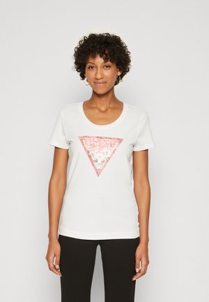 T-shirt en coton blanc à col rond, avec un graphique triangulaire pailleté rose et le texte "GUESS" au centre.