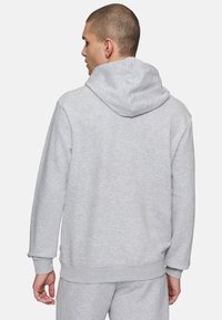 Grå huvtröja med texturerad tyg, lös passform samt ribbade ärmslut och nederkant. Har en bakhuvud och minimalistiska design detaljer.