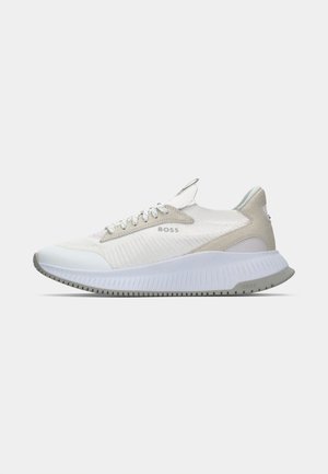 Sport shoe with a white mesh upper, beige accents, and a textured, flexible sole. Features a logo on the side and lace closure.