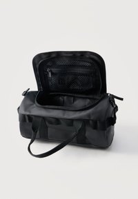 Μαύρη κυλινδρική τσάντα duffel με φερμουάρ στην ανοιχτή κορυφή, εσωτερική τσέπη από δίχτυ με φερμουάρ και διπλές λαβές μεταφοράς σε απλό φόντο.