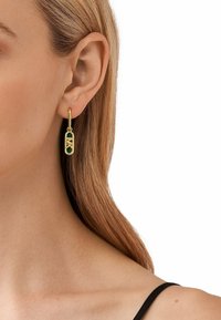 Guldtonade hängörhängen med grön emaljinlägg, med en geometrisk design och krokfäste. Slät yta med en glänsande textur.