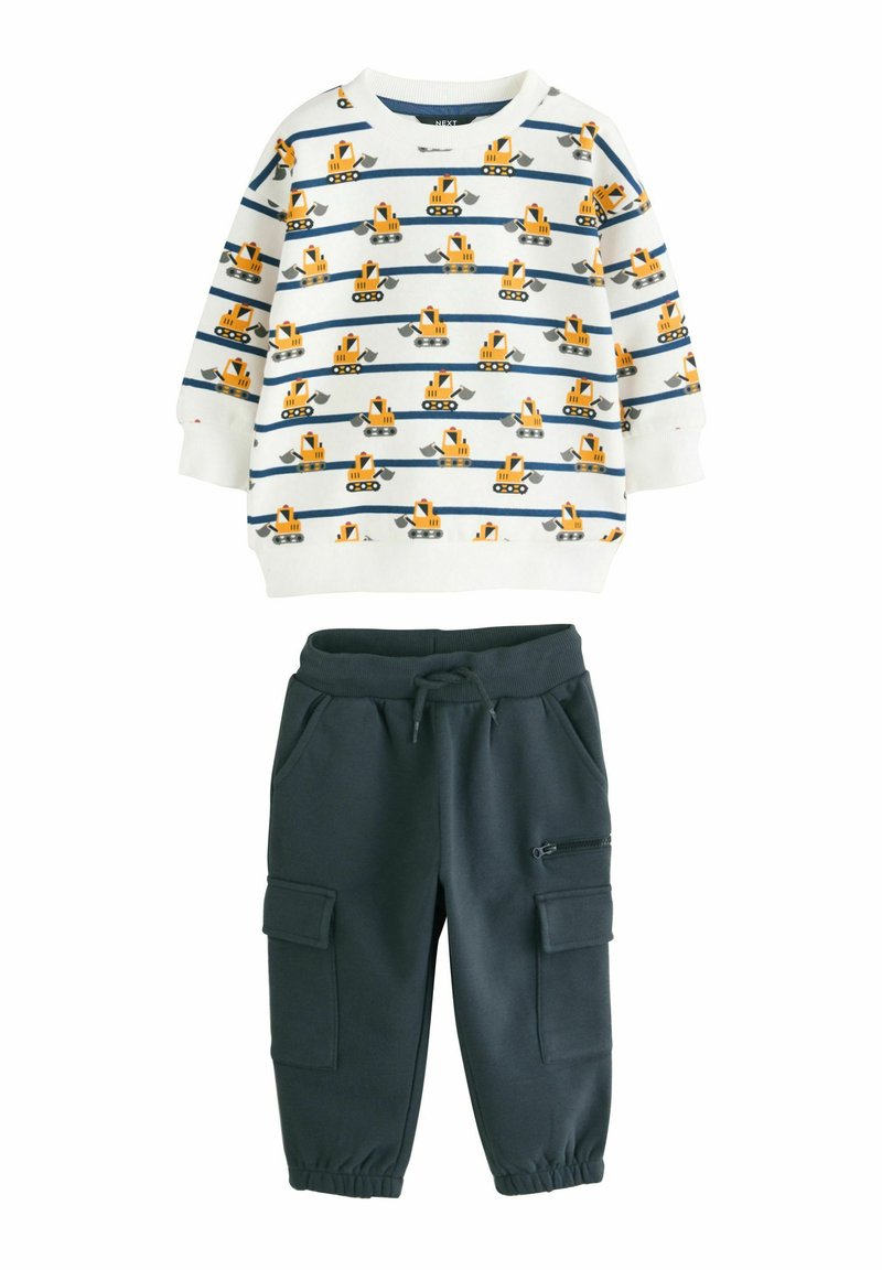 Sweatshirt in het wit met blauwe strepen en gele graafmachinepatronen, gecombineerd met donkergrijze cargobroek met rits- en patchzakken.