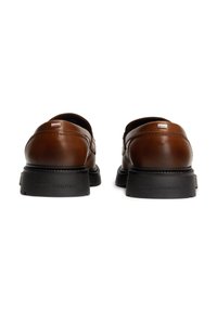 Braune Lederschuhe mit glatter Textur, runder Zehenform und schwarzer Gummisohle. Mit einem auf der Ferse eingeprägten Logo.