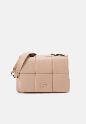 Beige quilted leather handbag with padded square panels, short leather strap, and metal chain detail on a plain background.