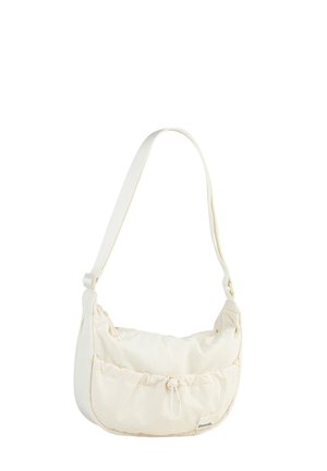 Cream-colored shoulder bag made of soft fabric with a ruched design, featuring a drawstring closure and adjustable strap.