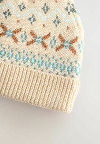 Strikket hue i creme med blå, brun og teal geometriske mønstre. Ribbet kant forneden; tekstureret uldstof.