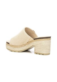 Sandalo scivoloso in tessuto intrecciato beige con una fascia larga, fodera in pelle e tacco chunky in corda intrecciata, caratterizzato da una superficie testurizzata e retro aperto.