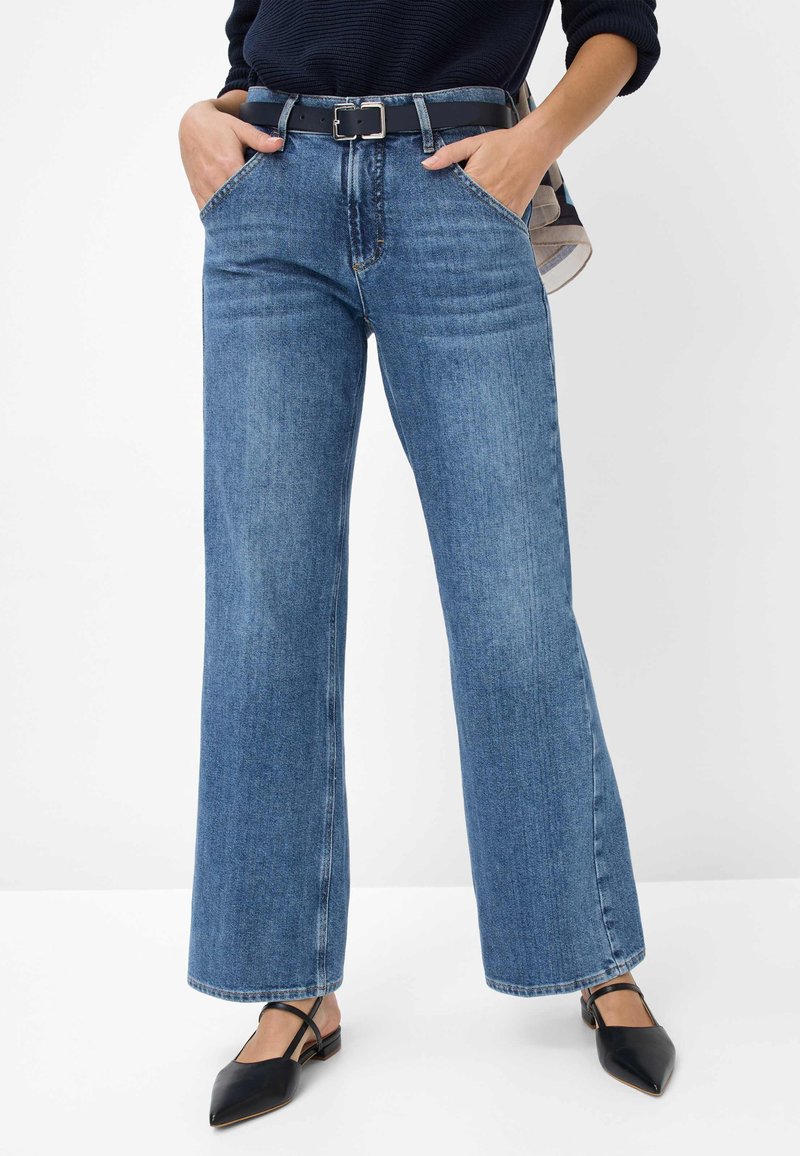 Blauwe denim wijde jeans met een hoge taille, voorzien van voorzakken en een zwarte riem. Glad textuur met een klassiek vijf-zakken ontwerp.