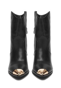 Czarne skórzane botki za kostkę z ostrym noskiem i złotym metalowym czubkiem. Posiadają smukły design, gładką teksturę oraz kanciaste wycięcia po bokach.
