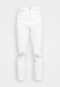 Jeans de mezclilla blanca con desgastes en las rodillas, cintura alta, diseño tradicional de cinco bolsillos y pierna ligeramente ajustada.