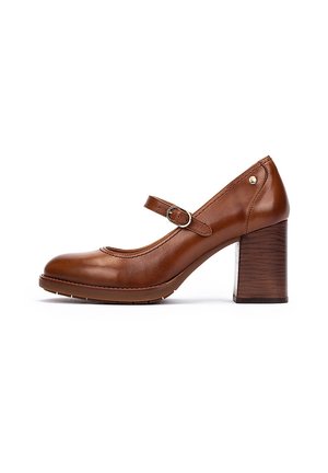 Talons en cuir marron de style Mary Jane avec un bout rond, une sangle ajustable et un talon en bloc en bois texturé. Fini lisse avec des accents minimaux.