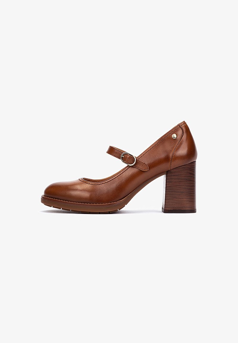 Talons en cuir marron de style Mary Jane avec un bout rond, une sangle ajustable et un talon en bloc en bois texturé. Fini lisse avec des accents minimaux.