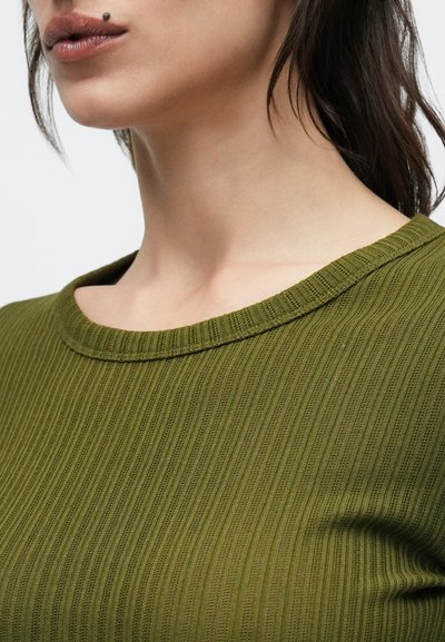 Κορυφή από ριμπ πλεκτό σε ελιά πράσινο με φαρδύ, στρογγυλό λαιμόκοψη. Η υφή είναι μαλακή και με ανάγλυφο μοτίβο, με οριζόντιες ρίγες σε όλη την επιφάνεια.