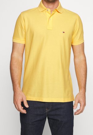 Polo shirt in bright yellow cotton with a classic collar, short sleeves, and a small logo accent on the left chest.