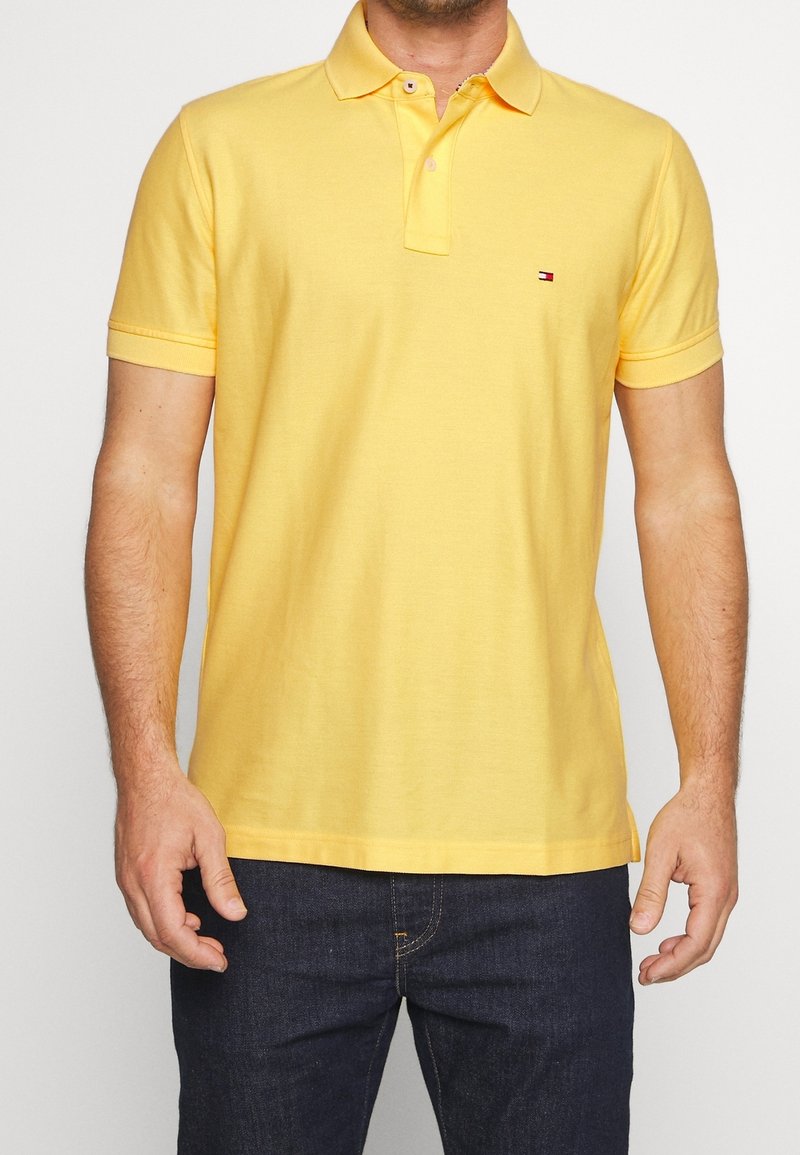 Polo shirt in bright yellow cotton with a classic collar, short sleeves, and a small logo accent on the left chest.