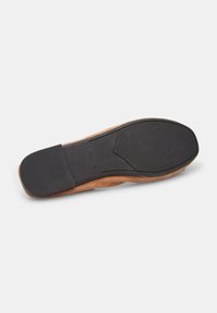 Brown suede shoe sole with a textured black rubber bottom, featuring a smooth outline and slight heel elevation.