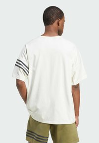 Krátký rukáv tričko z off-white bavlny s uvolněným střihem, které má na každém rameni tři černé pruhy a zakřivený lem.